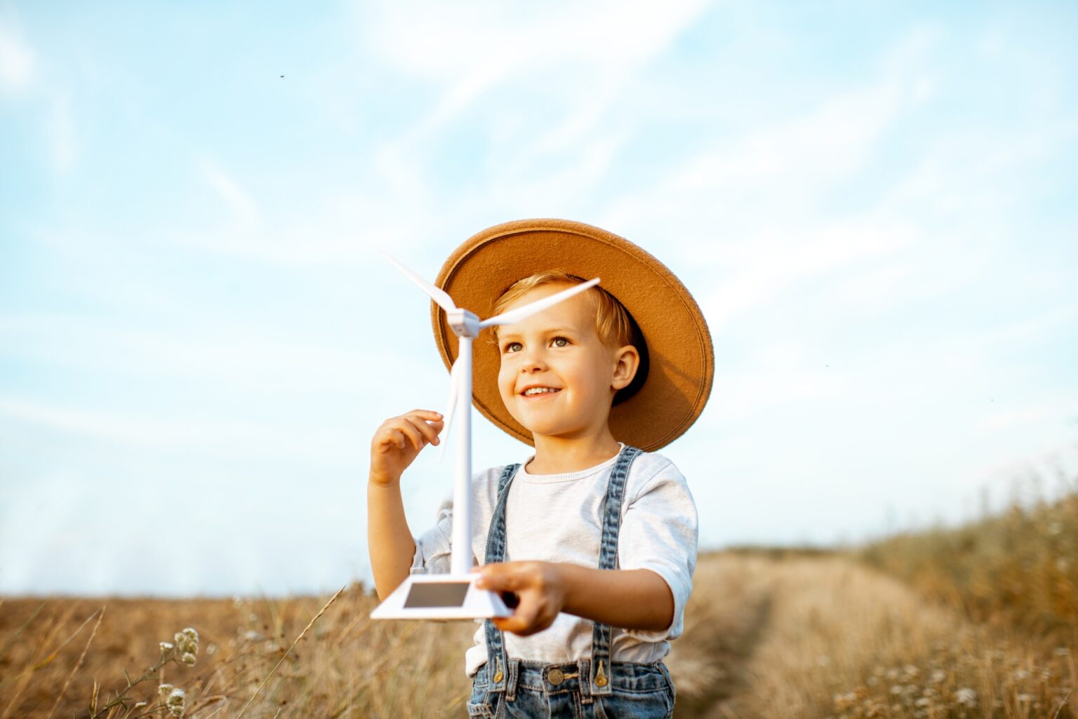 Boy playing with toy wind turbine outdoors